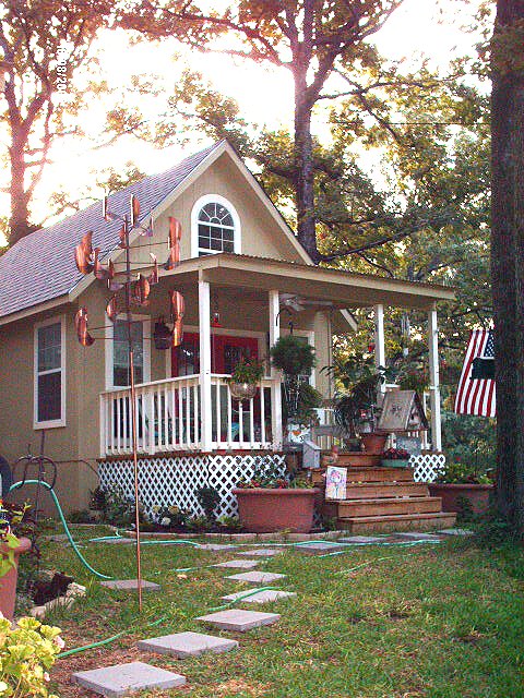 the 14 foot wide cottage with its red door, front porch and planted yard