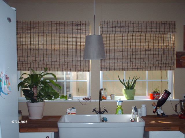 kitchen sink set under a run of windows with woven blinds