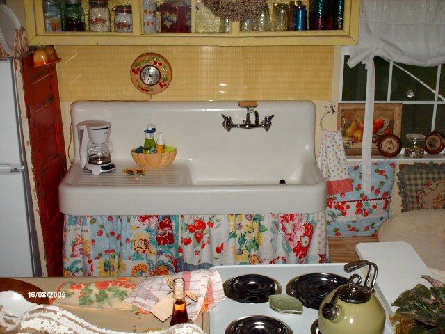 cottage kitchen with a farmhouse sink, a yellow tile backsplash and a red door