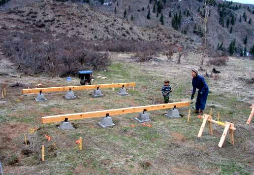 hand dug pier foundation with pavers, piers and the main beams laid out on the building site