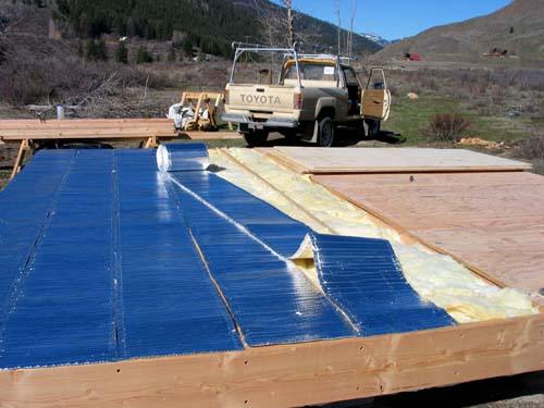 foil faced bubble wrap and batt insulation going into the floor system, with the pickup truck parked behind
