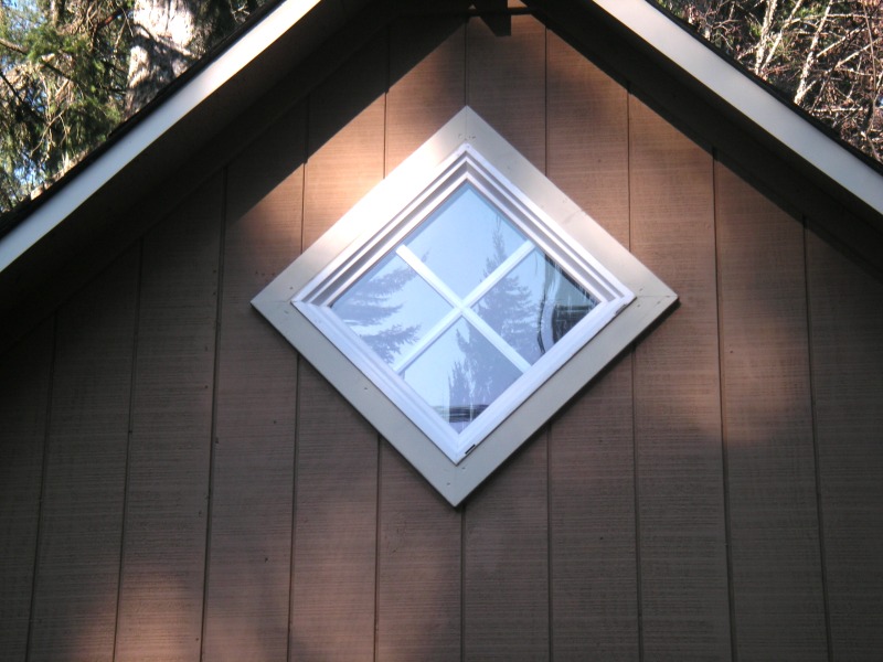 square window set on the diagonal high in the gable end of the shop