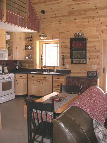 kitchen and dining table seen from the great room, with the loft railing above