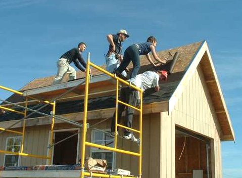 roof jacks and scaffolding on the steep roof of the 12x18 cabin