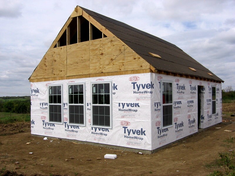 the cottage wrapped in Tyvek with the gable end sheathed and the roof decked