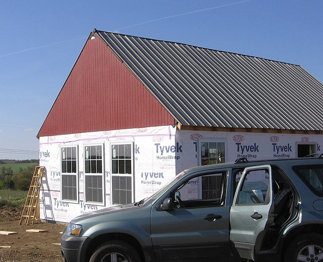 red panel siding on the gable end with the metal roofing in place