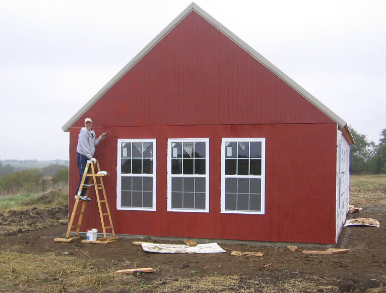 painting the red gable end wall from a step ladder