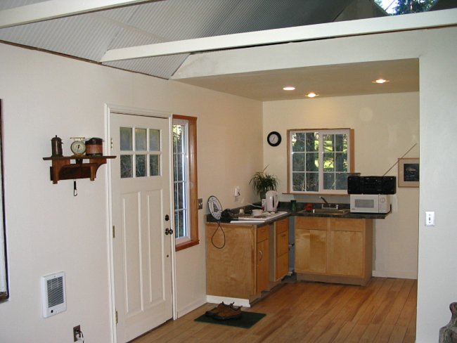 mini kitchen with a loft and skylight above it inside the studio office