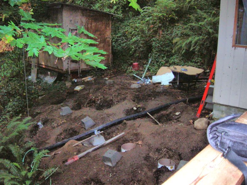 footings and a drain line going in on the wooded slope beside the existing house
