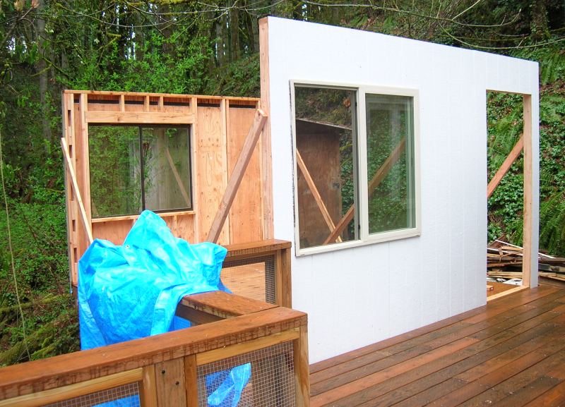 two walls of the 12x14 office standing on the new deck, windows already in