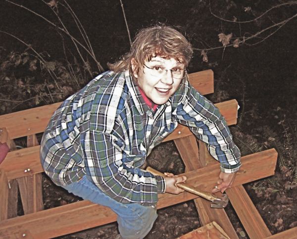 the owner nailing off framing at the outside edge of the deck after dark