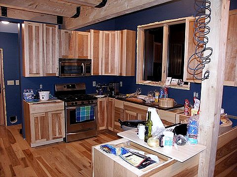 kitchen with hickory cabinets against blue walls and a hickory floor