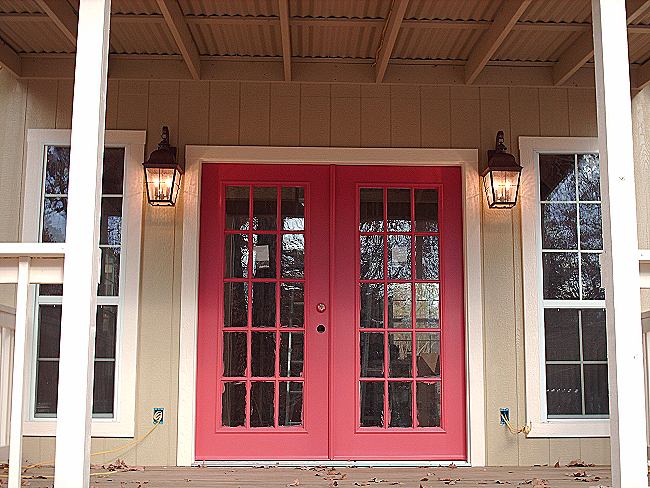 red double French doors under the front porch roof of the cottage