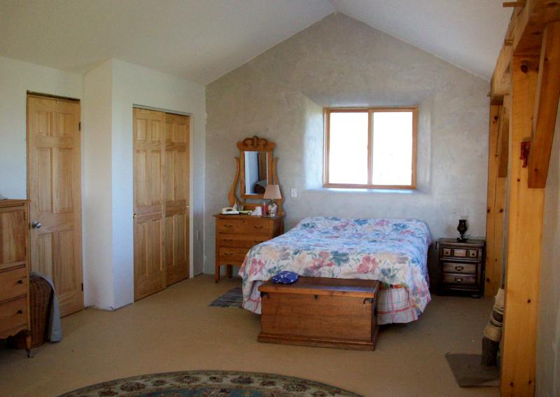 the other end of the upstairs bedroom, with closet doors and a window in a deep plastered well