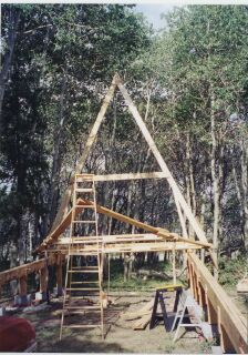 the first A-frame standing on the beams with the second propped on a ladder