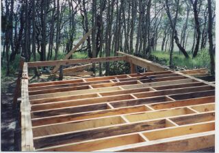 rough-cut 2x8 floor joists framed over the beams