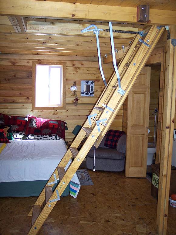 pull down loft ladder set on the cabin floor and ready to climb