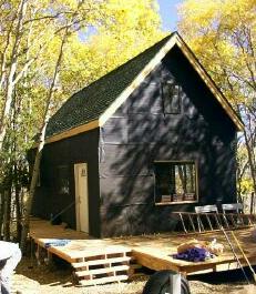 the 14x24 cabin with its steep gable roof and front deck