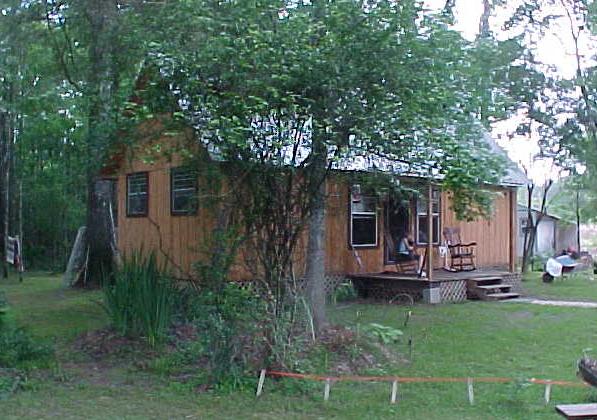 front of the 14x36 Little House cabin with a covered porch and two rocking chairs