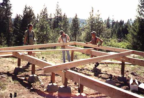 three builders framing the post and pier foundation on concrete block piers