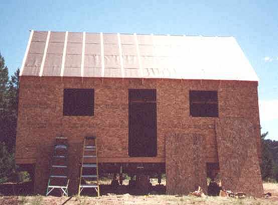 gable end of the 14x24 cabin sheathed in OSB with roofing paper over the steep roof